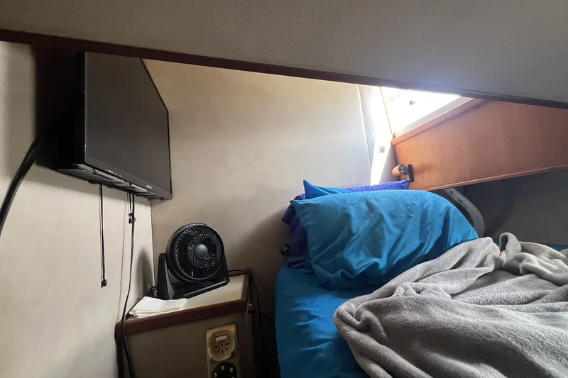 Slide: The Image of Cozy cabin interior of 1986 Chris Craft 47 Constellation with bed, TV, and fan. - 71