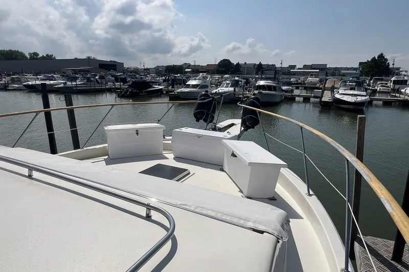 Slide: The Image of 1986 Chris Craft 47 Constellation yacht docked at a marina under a cloudy sky. - 12