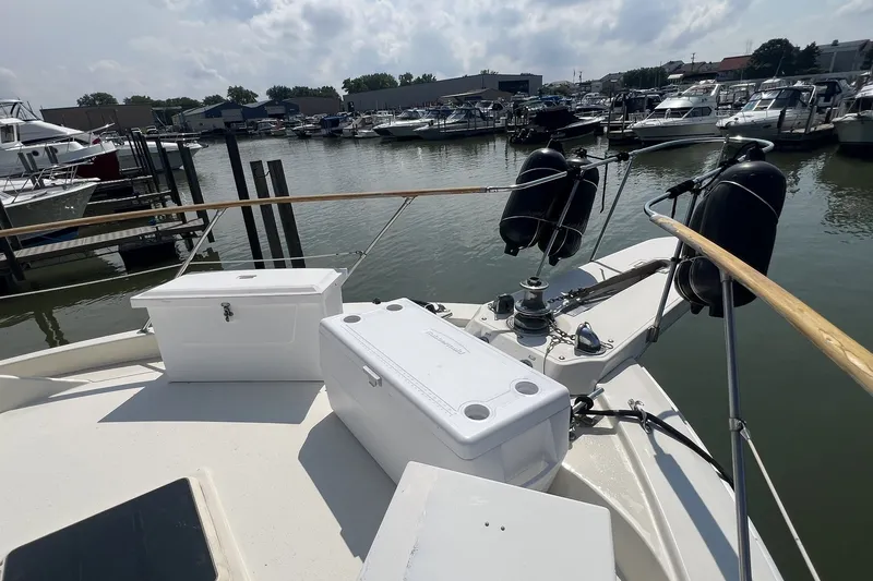 Slide: The Image of 1986 Chris Craft 47 Constellation yacht docked at marina, featuring deck storage and fenders. - 15