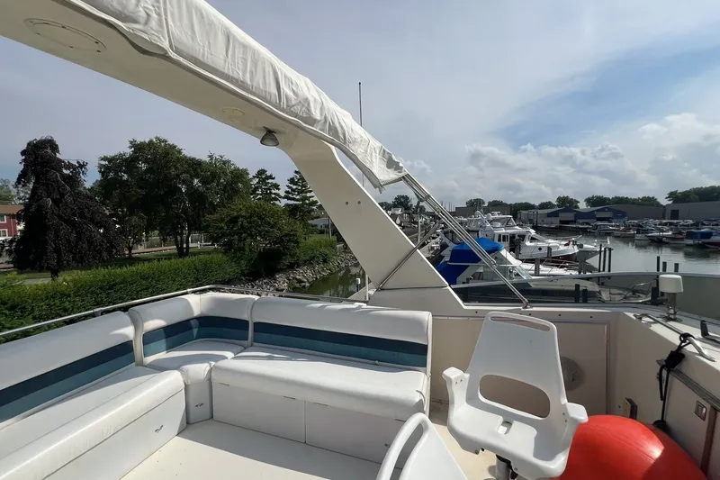 Slide: The Image of 1986 Chris Craft 47 Constellation yacht deck with seating, docked at marina. - 90