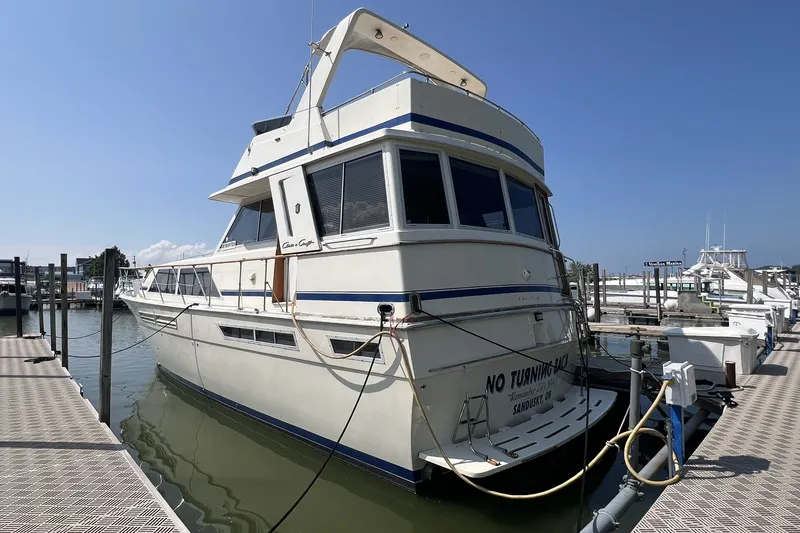 Slide: The Image of 1986 Chris Craft 47 Constellation yacht docked at marina under clear blue sky. - 4