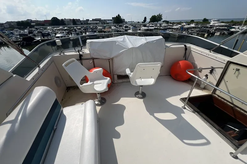 Slide: The Image of 1986 Chris Craft 47 Constellation yacht deck with seating and marina view. - 93