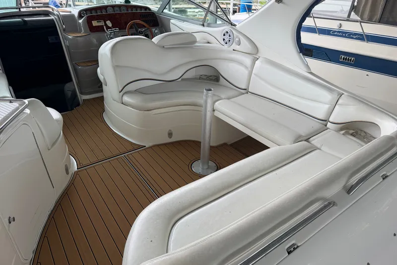 Slide: The Image of Interior of a 2000 Wellcraft 3300 Martinique boat with white seating and wood flooring. - 9