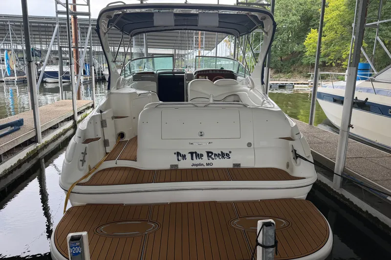 Slide: The Image of 2000 Wellcraft 3300 Martinique boat docked, rear view, with teak deck and canopy. - 8