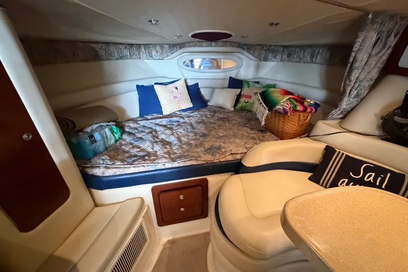 Slide: The Image of Cozy cabin interior of 2000 Wellcraft 3300 Martinique with bed, pillows, and nautical decor. - 22