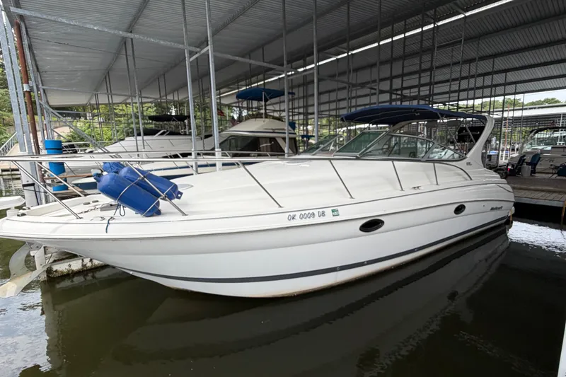 Slide: The Image of 2000 Wellcraft 3300 Martinique boat docked in a covered marina. - 7