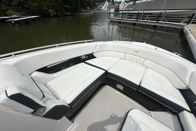 Slide: The Image of 2021 Regal 2800 Bowrider with spacious white seating, docked by a calm lake. - 15