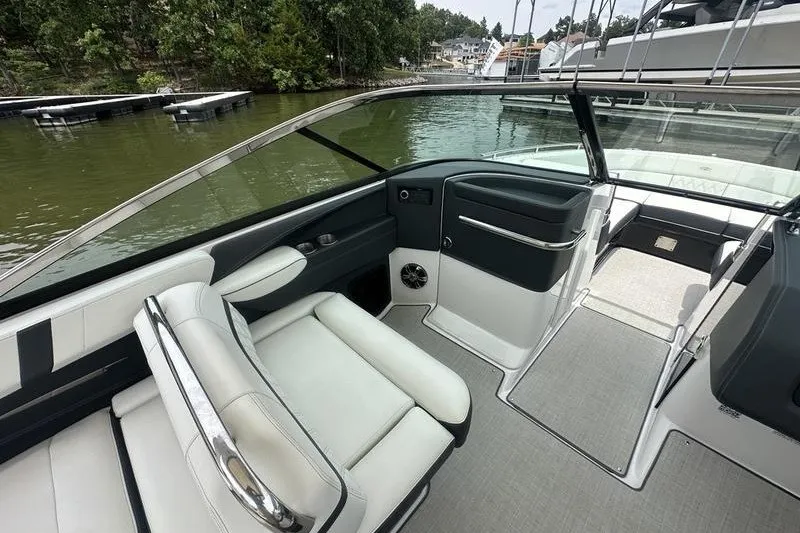 Slide: The Image of 2021 Regal 2800 Bowrider interior with sleek seating and modern design on a lake. - 12