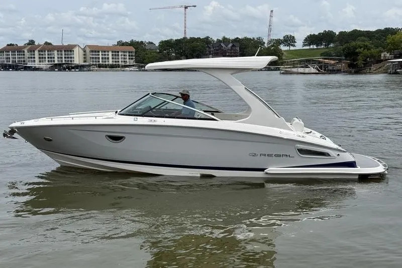 Slide: The Image of 2021 Regal 2800 Bowrider boat on calm water, with scenic background. - 3