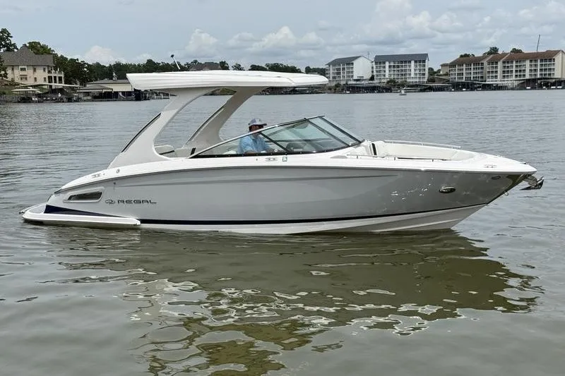 Slide: The Image of 2021 Regal 2800 Bowrider boat on calm water, with modern design and sleek lines. - 5