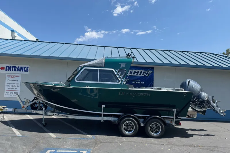 The Image of 2027 Duckworth 20 Discovery boat on trailer, parked outside a marine store. - 1