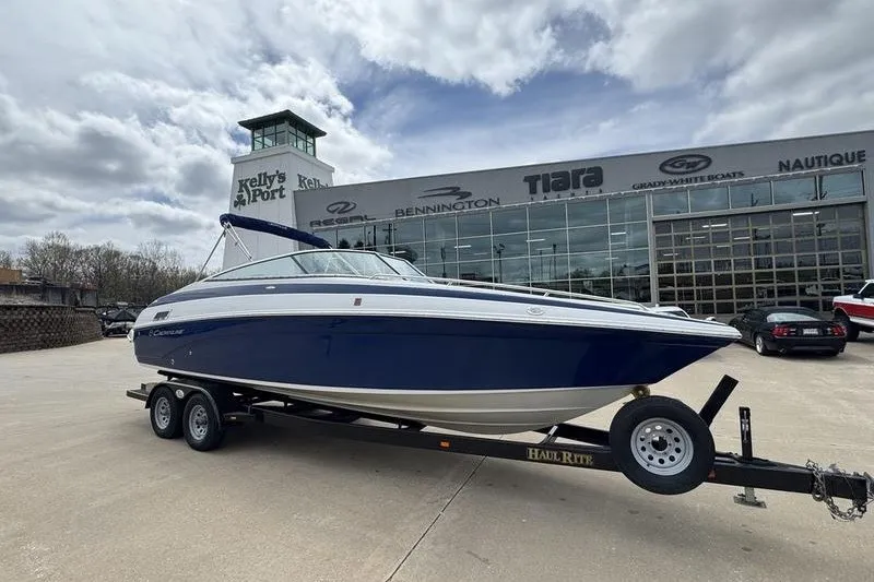 The Image of 2014 Crownline 275 SS boat on trailer at dealership, cloudy sky background. - 1