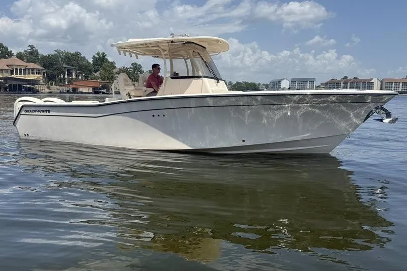 Slide: The Image of 2024 Grady-White Canyon 306 boat on calm water, clear sky background. - 6