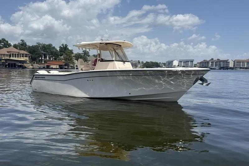 Slide: The Image of 2024 Grady-White Canyon 306 boat on calm water under a partly cloudy sky. - 5