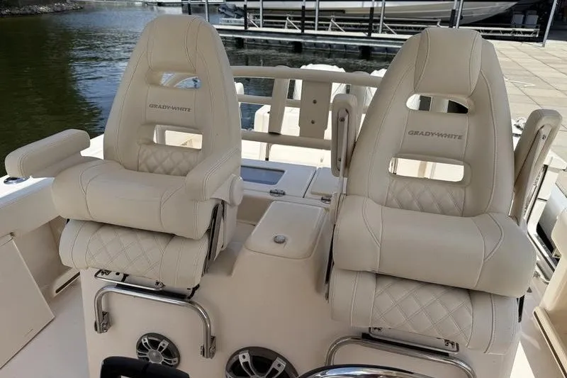 Slide: The Image of 2024 Grady-White Canyon 306 boat seats, luxurious white leather design, dockside view. - 19