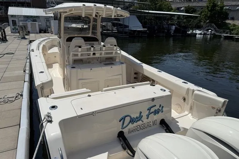 Slide: The Image of 2024 Grady-White Canyon 306 boat docked, featuring spacious deck and dual engines. - 24