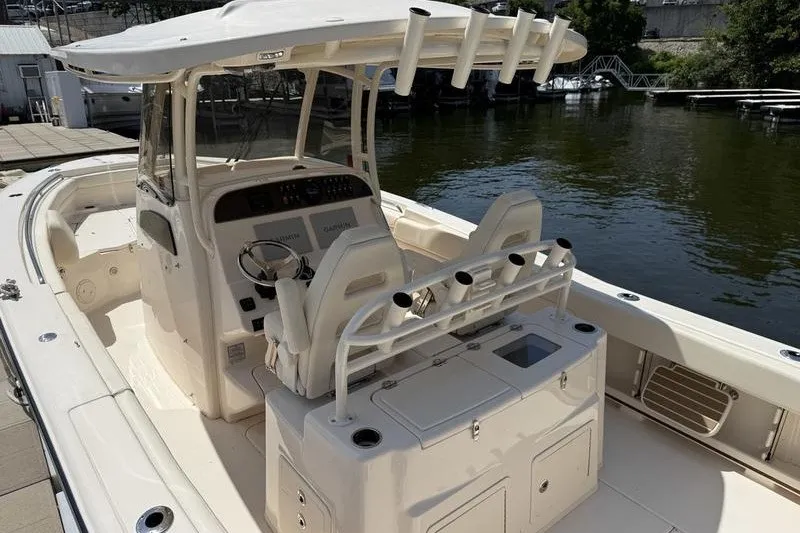 Slide: The Image of 2024 Grady-White Canyon 306 boat interior with helm and seating, docked by the water. - 22