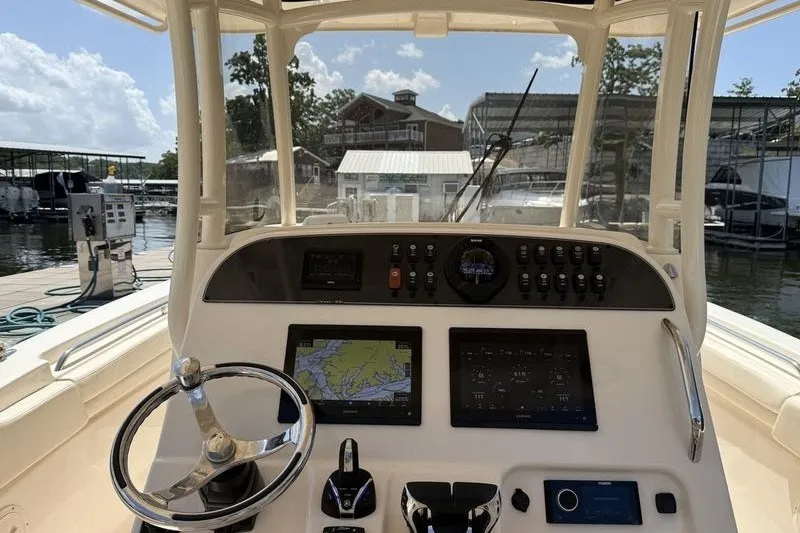 Slide: The Image of 2024 Grady-White Canyon 306 helm with navigation screens and controls at marina. - 16