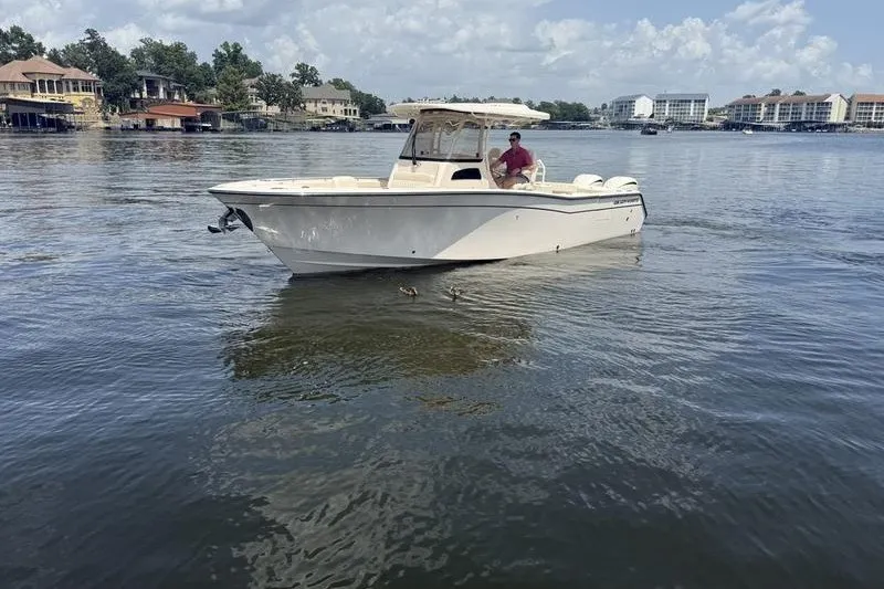 Slide: The Image of 2024 Grady-White Canyon 306 boat on a calm lake with scenic background. - 3