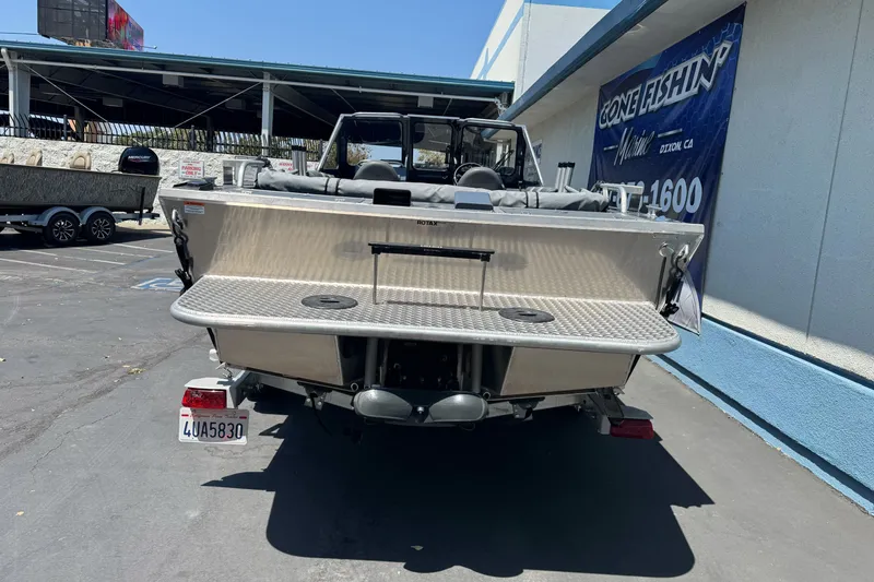 Slide: The Image of 2021 Hewescraft 180 River Runner boat parked at dealership, rear view. - 6