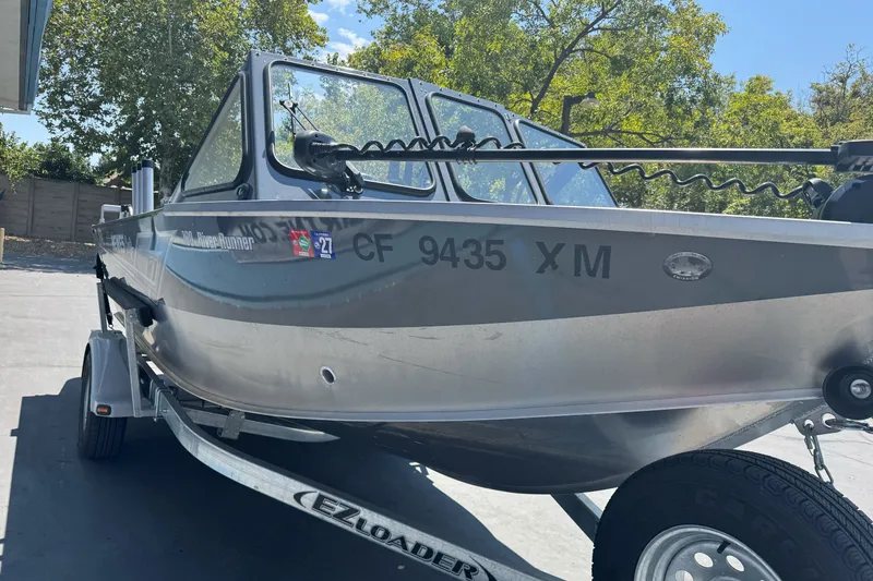 Slide: The Image of 2021 Hewescraft 180 River Runner boat on EZ Loader trailer, parked outdoors. - 4