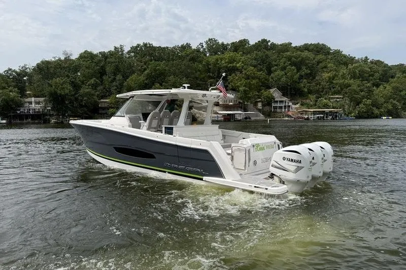 Slide: The Image of 2021 Regal 38 SAV boat cruising on a lake with Yamaha engines. - 7