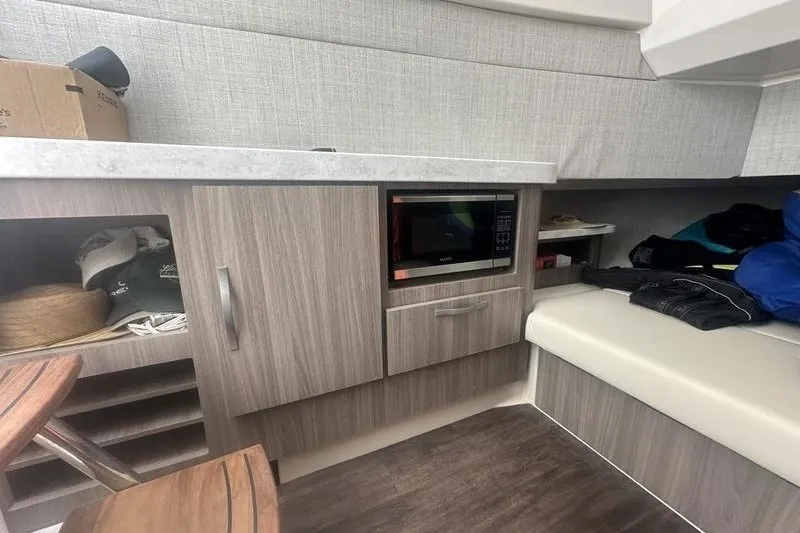 Slide: The Image of 2021 Regal 38 SAV interior with microwave, storage cabinets, and seating area. - 18