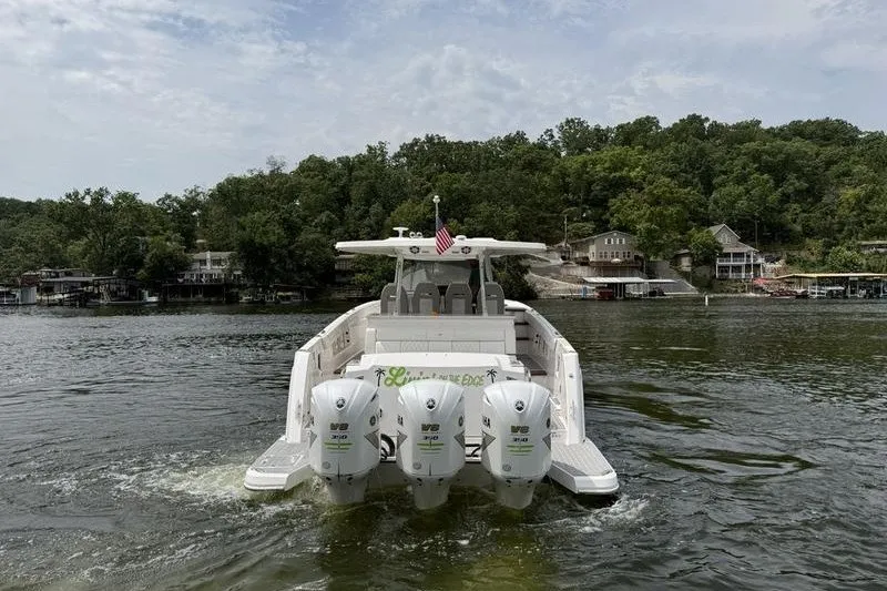 Slide: The Image of 2021 Regal 38 SAV boat with four engines cruising on a scenic lake. - 8
