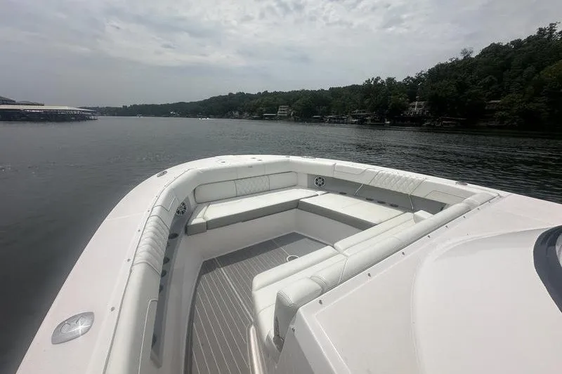 Slide: The Image of 2021 Regal 38 SAV boat with spacious seating on a calm lake. - 11