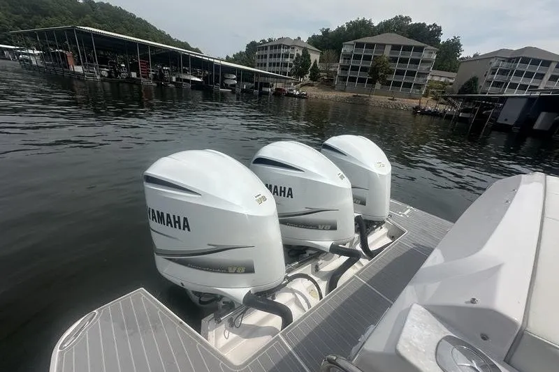 Slide: The Image of 2021 Regal 38 SAV with triple Yamaha V8 engines docked on a serene lake. - 25