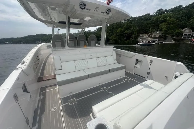 Slide: The Image of 2021 Regal 38 SAV boat interior with spacious seating on a calm lake. - 23