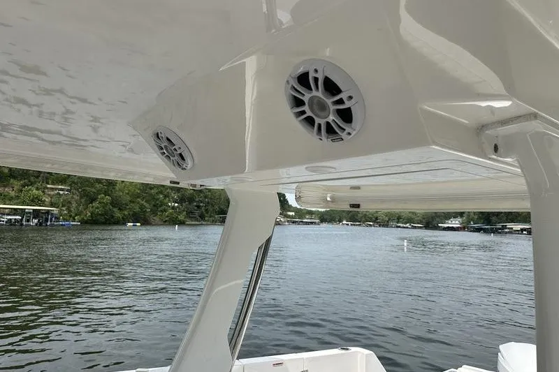 Slide: The Image of 2021 Regal 38 SAV boat speakers under canopy on a serene lake. - 21