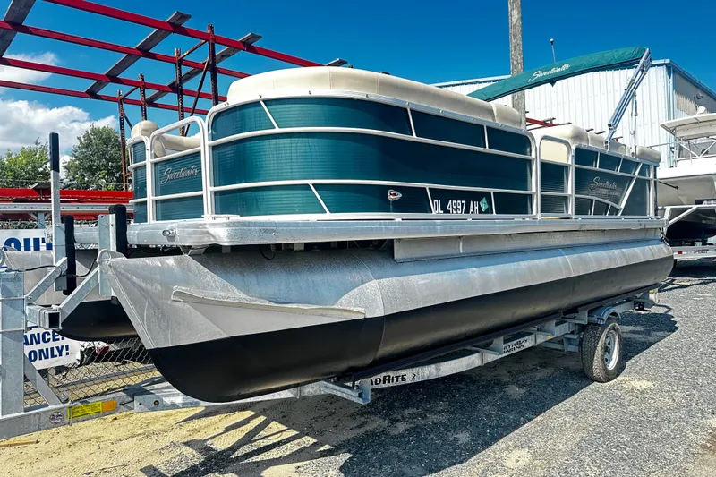 The Image of 2015 Godfrey 2286 Sweetwater Pontoon on trailer, parked outdoors under blue sky. - 0