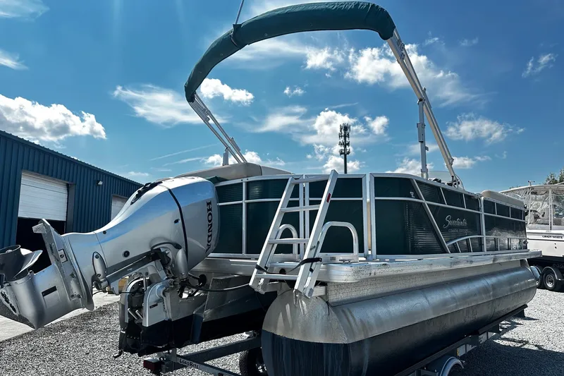 Slide: The Image of 2015 Godfrey 2286 Sweetwater Pontoon with Honda outboard motor under clear blue sky. - 2
