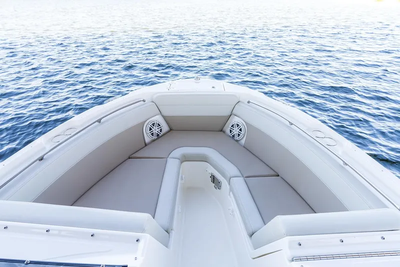 Slide: The Image of Manufacturer Provided Image: 2026 Boston Whaler 210 Vantage boat interior with cushioned seating on calm water. - 8