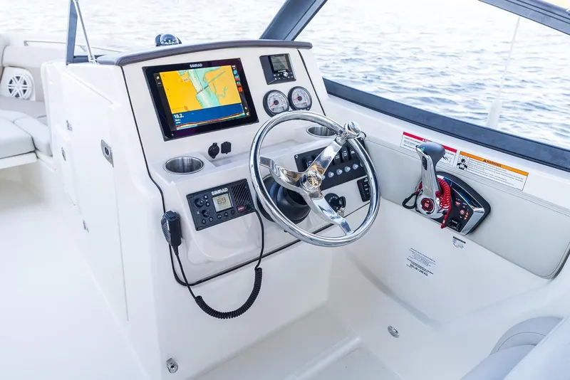 Slide: The Image of Manufacturer Provided Image: 2026 Boston Whaler 210 Vantage boat dashboard with navigation system and steering wheel. - 11