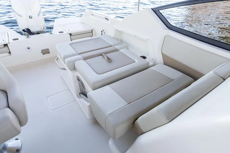 Slide: The Image of Manufacturer Provided Image: 2026 Boston Whaler 210 Vantage boat interior with beige seating and water view. - 12