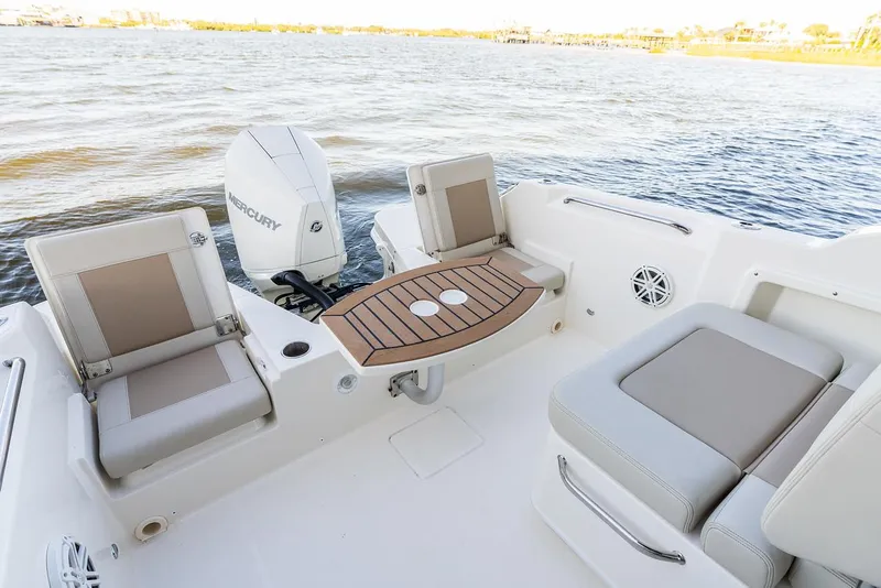 Slide: The Image of Manufacturer Provided Image: 2026 Boston Whaler 210 Vantage boat interior with seating and table on water. - 13