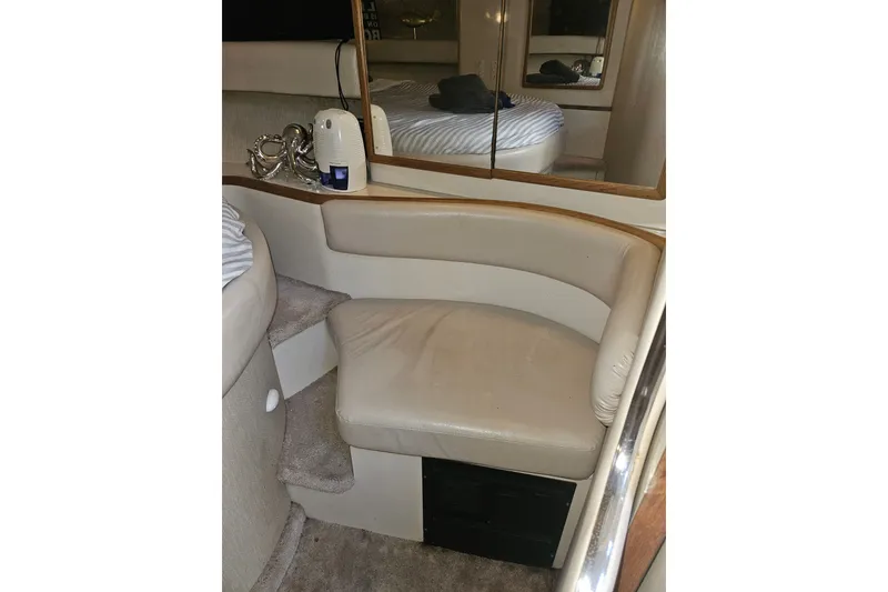 Slide: The Image of Interior of 1996 Sea Ray 370 Express Cruiser with beige seating and mirrored wall. - 24