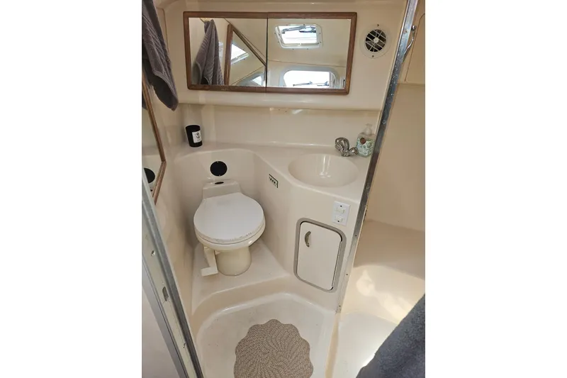 Slide: The Image of Bathroom interior of 1996 Sea Ray 370 Express Cruiser with sink, toilet, and mirror. - 27