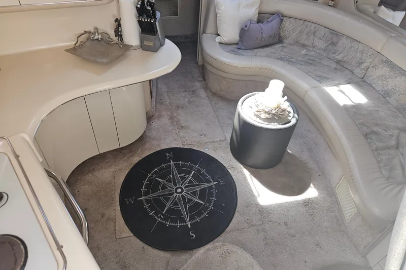 Slide: The Image of Interior of a 1996 Sea Ray 370 Express Cruiser with curved seating and nautical decor. - 19