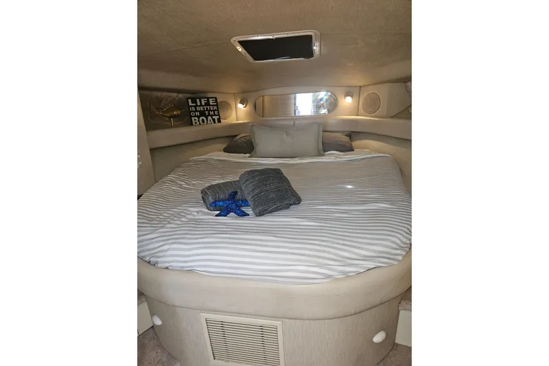 Slide: The Image of Cozy cabin interior of 1996 Sea Ray 370 Express Cruiser with striped bedding. - 22