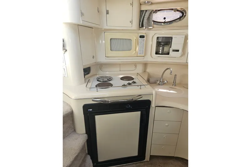 Slide: The Image of Compact kitchen in a 1996 Sea Ray 370 Express Cruiser with stove, microwave, and sink. - 14