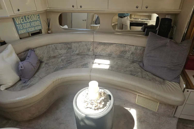 Slide: The Image of Interior of 1996 Sea Ray 370 Express Cruiser with curved seating and decorative pillows. - 17
