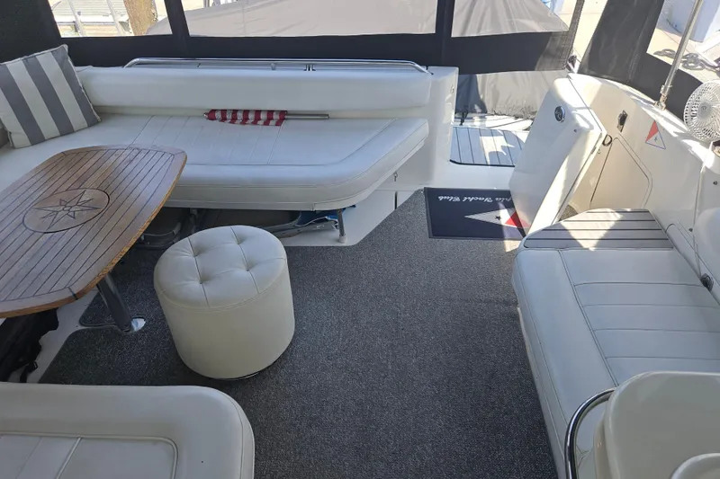 Slide: The Image of 1996 Sea Ray 370 Express Cruiser interior with white seating and wooden table. - 21