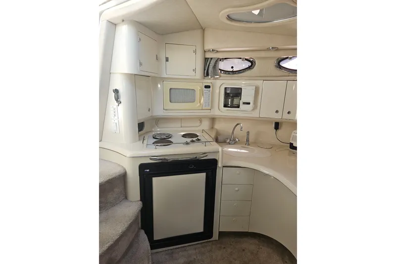 Slide: The Image of Interior of 1996 Sea Ray 370 Express Cruiser kitchen with appliances and storage. - 13