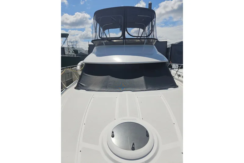 Slide: The Image of 2005 Meridian 368 Motoryacht with covered flybridge, docked under a partly cloudy sky. - 57