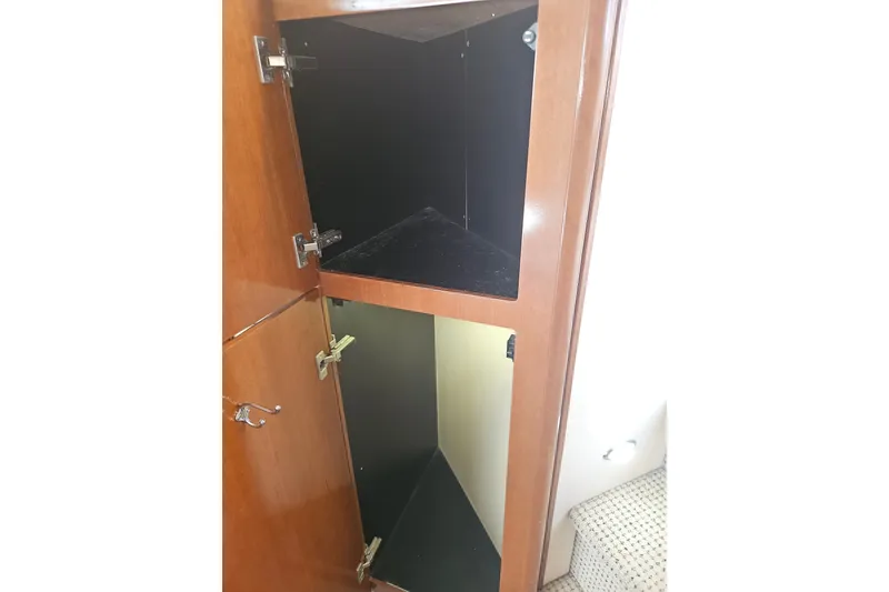 Slide: The Image of Open wooden cabinet on 2005 Meridian 368 Motoryacht, showcasing interior storage space. - 32
