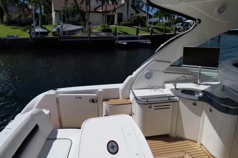 Slide: The Image of Luxurious 2007 Sea Ray 48 Sundancer yacht interior with seating and kitchenette by the water. - 19