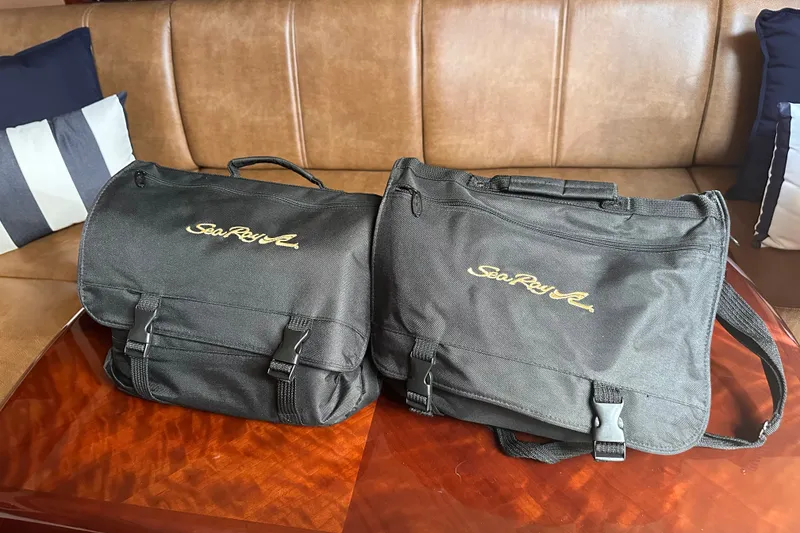 Slide: The Image of Black Sea Ray bags on a wooden table inside a 2007 Sea Ray 48 Sundancer yacht. - 52